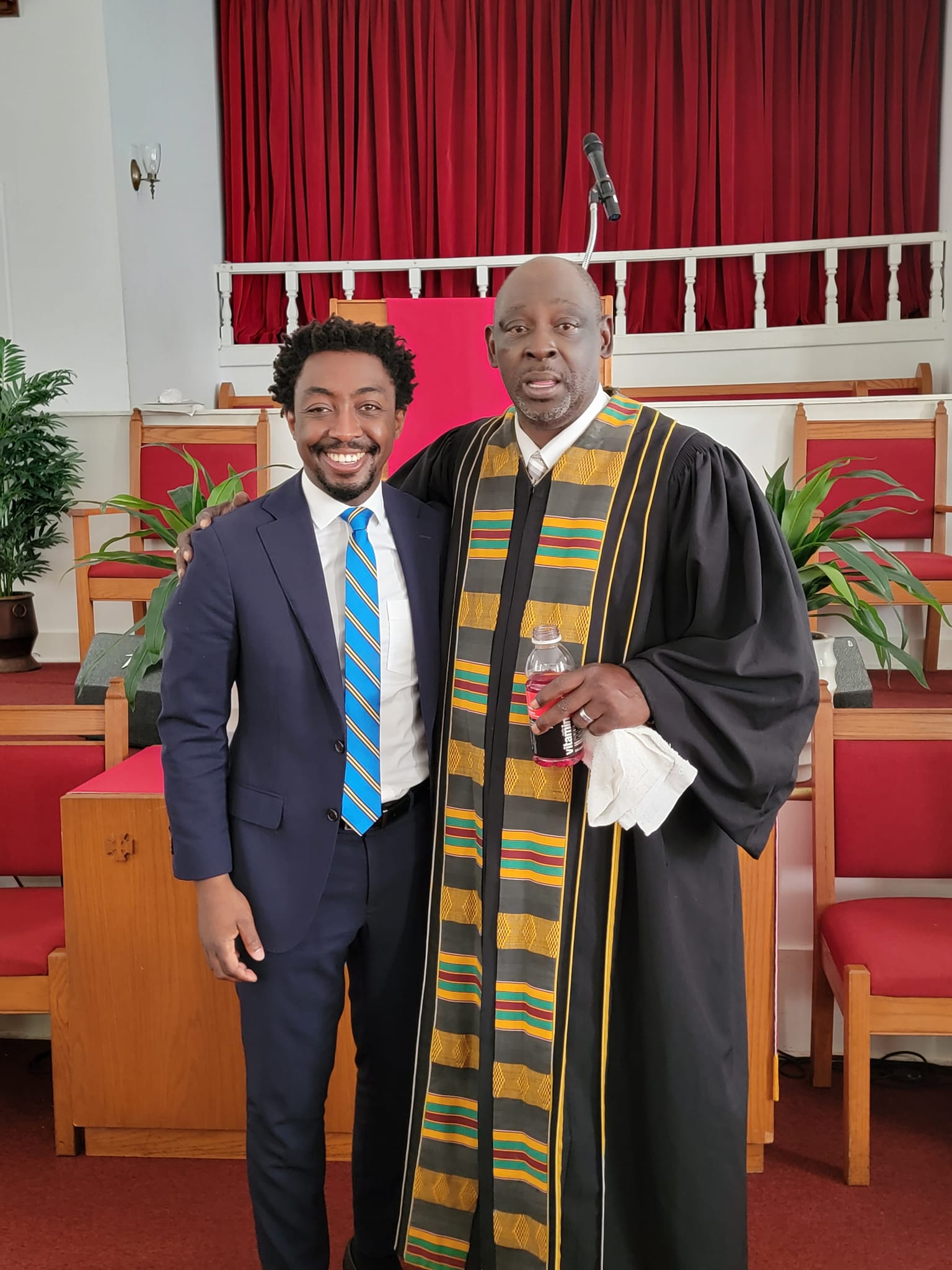Pastor and guest smiling together in the sanctuary